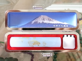 富士山世界文化遺産登録記念ハンコケースを用意いたしました。甲斐絹で織った富士をあしらい、内側には四季折々の美しい富士山を堪能できる、とてもオシャレな小粋なハンコアイテム新登場です。『INKAN‘ｓ金ぶどう』アズサブルー